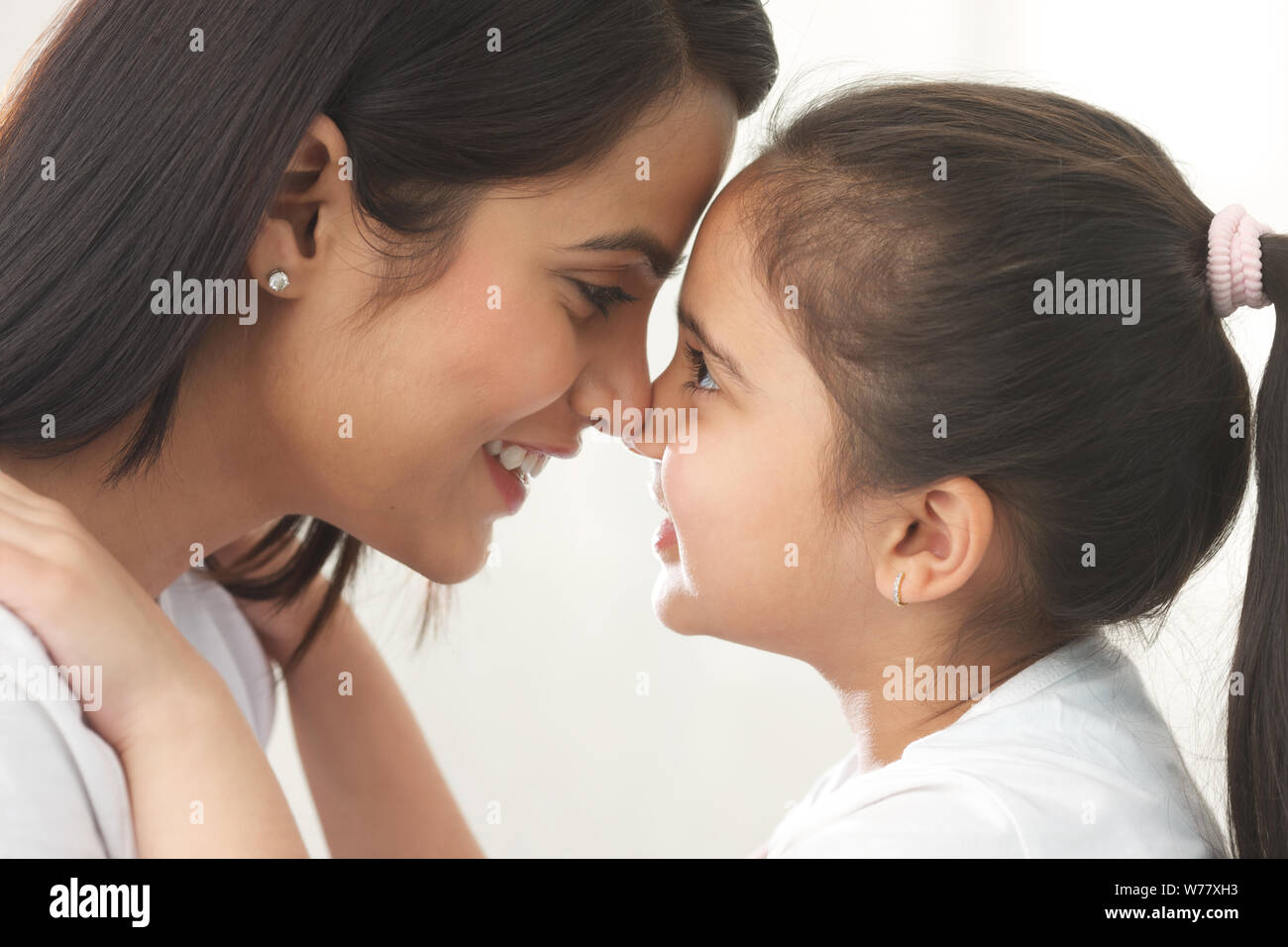 Close up woman rubbing noses mother hires stock photography and images