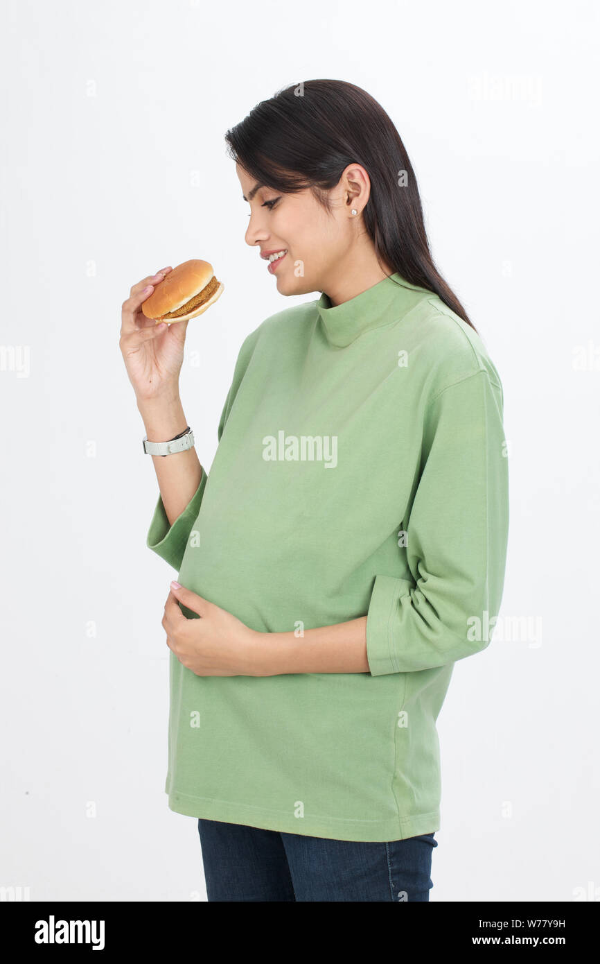Pregnant woman eating burger Stock Photo