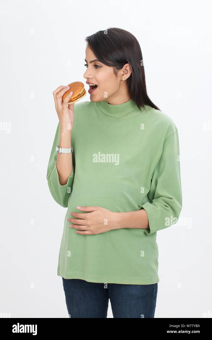 Pregnant woman eating burger Stock Photo
