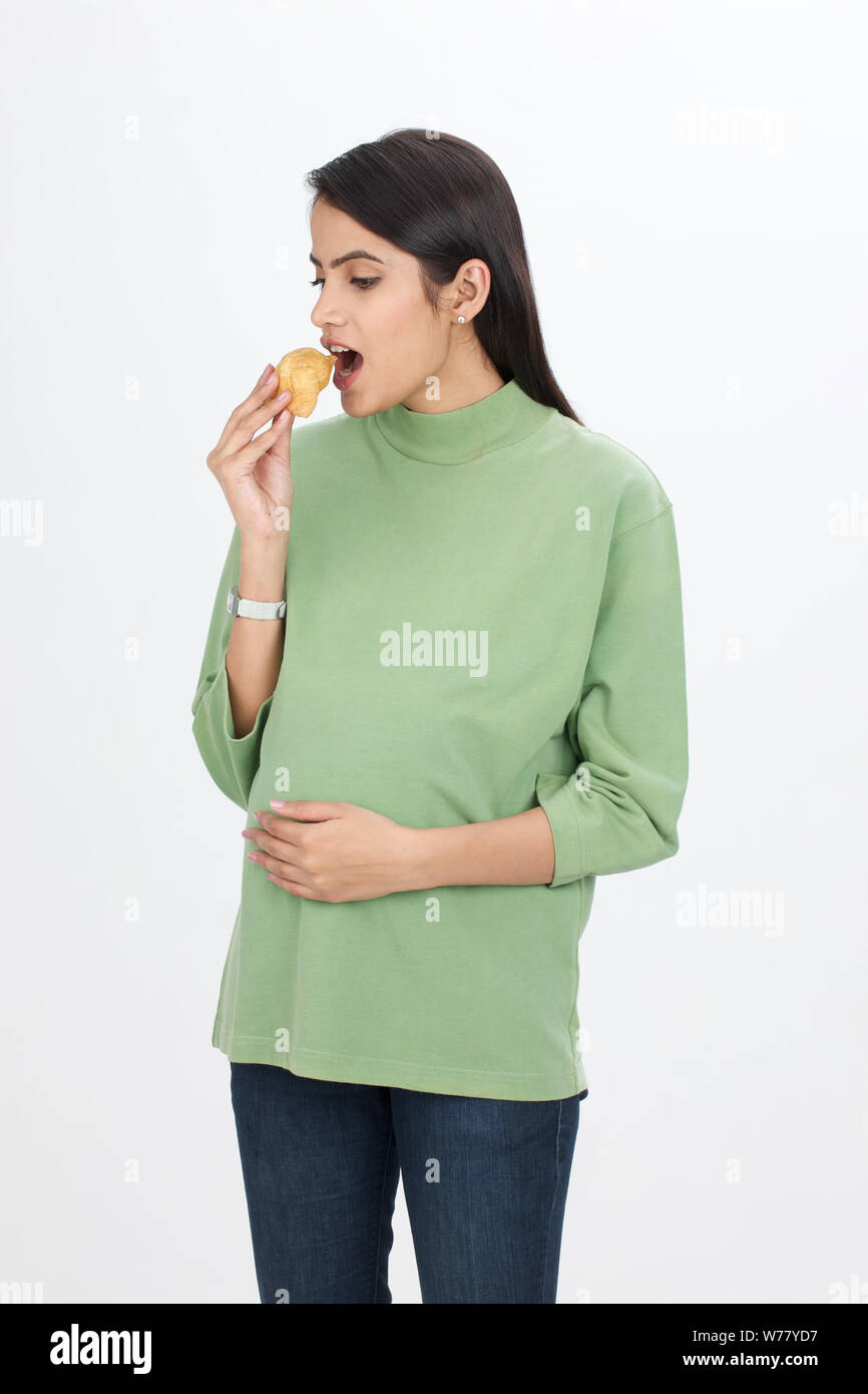 Pregnant woman eating samosa Stock Photo