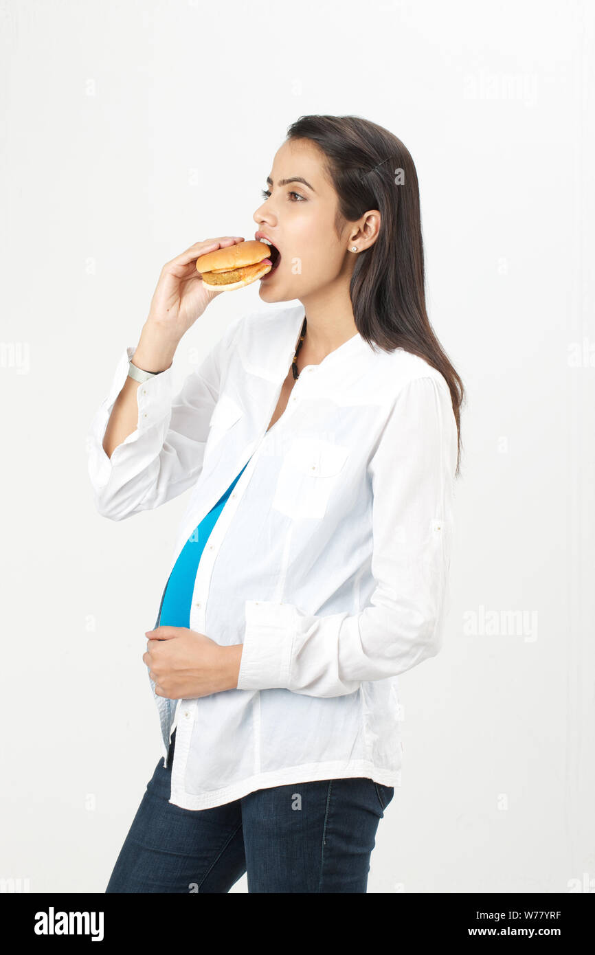 Pregnant woman eating burger Stock Photo