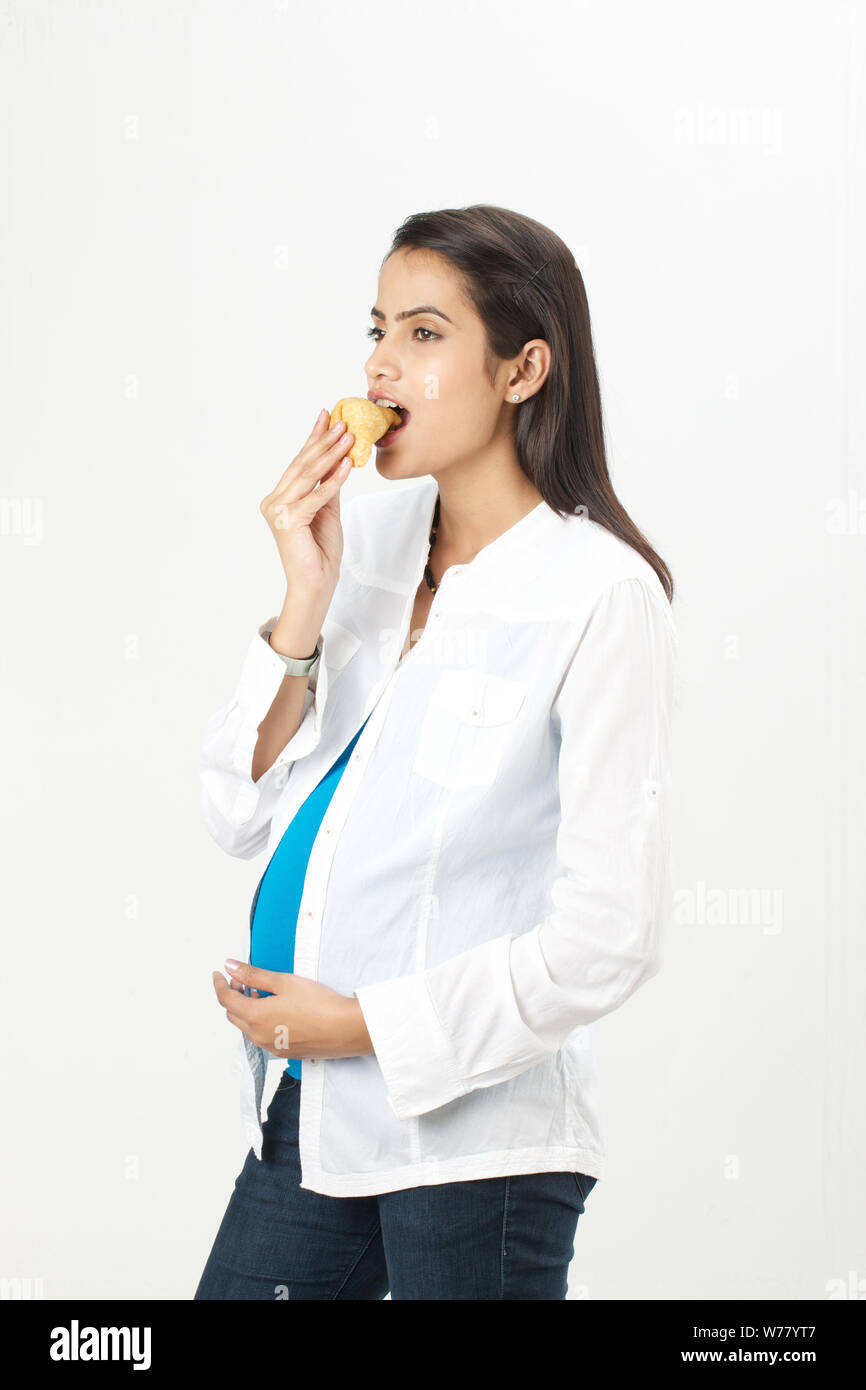 Pregnant woman eating samosa Stock Photo