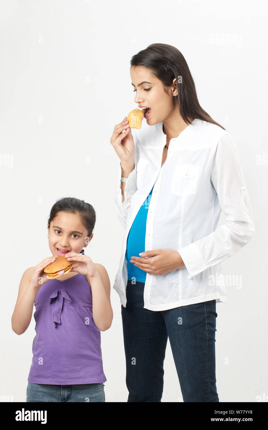 Pregnant woman and her daughter eating fast food Stock Photo