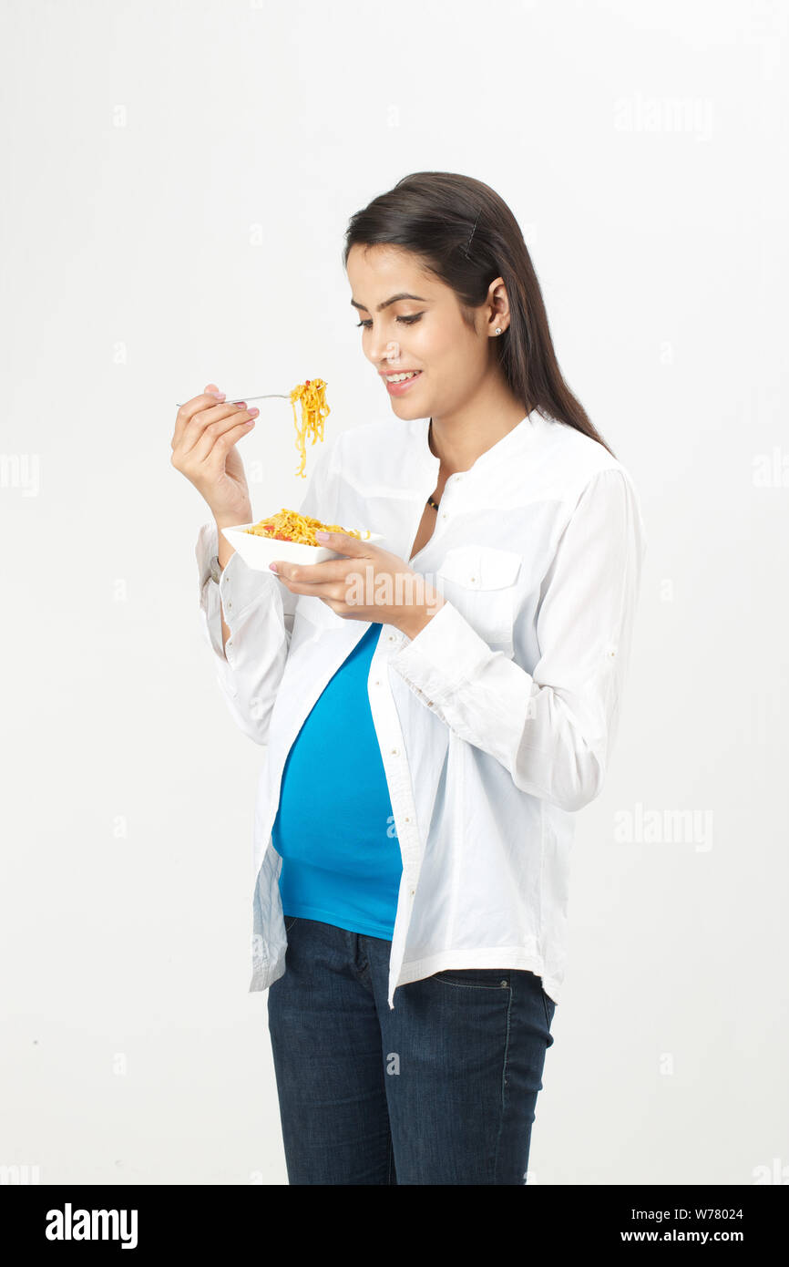 Pregnant woman eating noodles Stock Photo