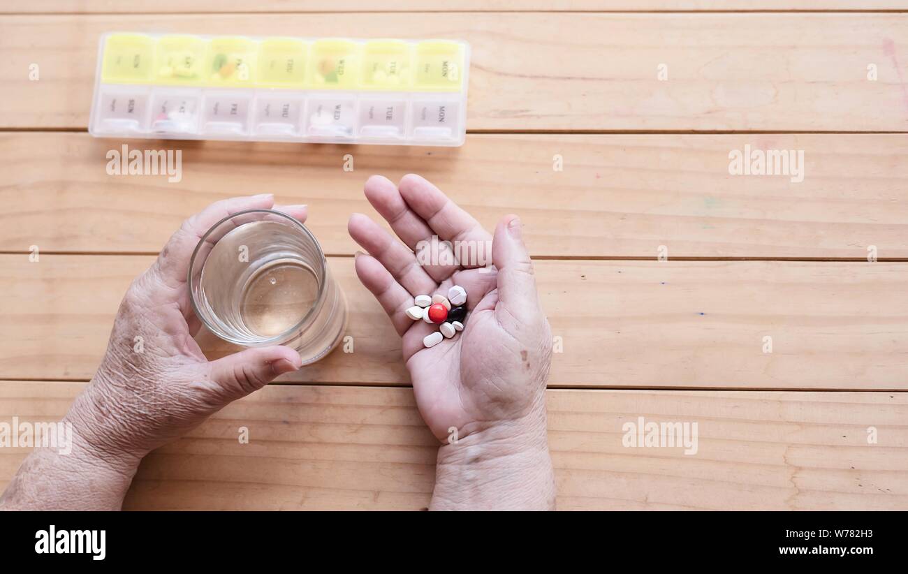 Old lady prepare to eat daily medicine pill - people healthcare with medicine pills concept Stock Photo