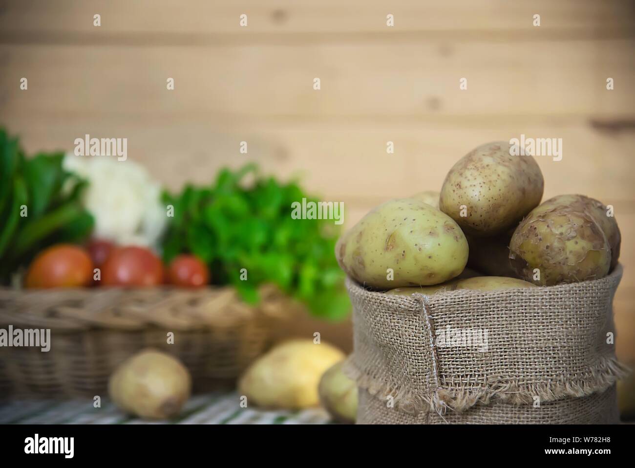 Fresh potato ready for cooking with potato sack background - potato cooking concept Stock Photo