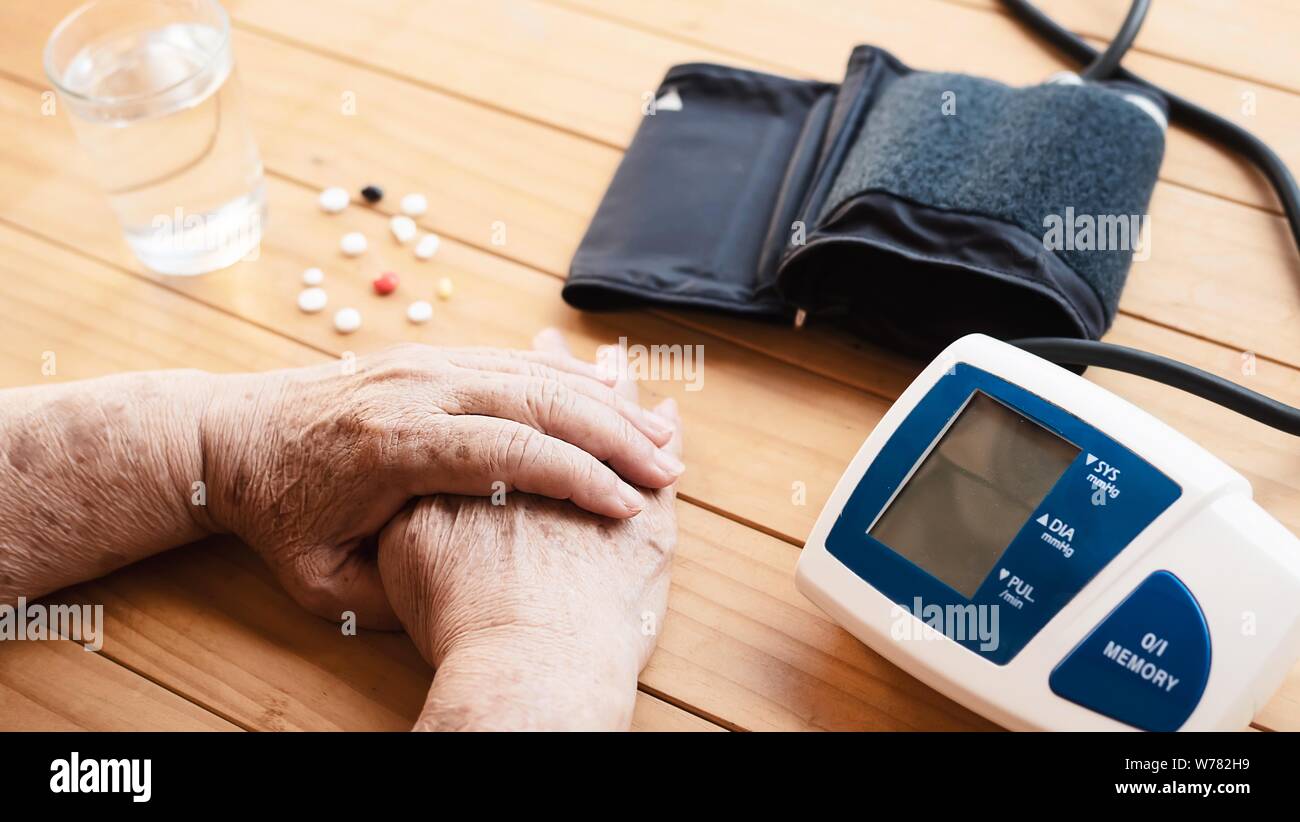 Old lady is being checked blood pressure using blood pressure monitor kid set - people with health care medical instrument set concept Stock Photo