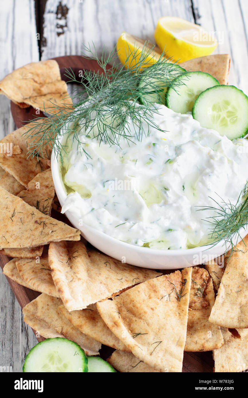 Traditional Greek Tzatziki dip sauce made with cucumber sour cream, Greek yogurt, lemon juice, olive oil and a fresh sprig of dill weed. Served with t Stock Photo