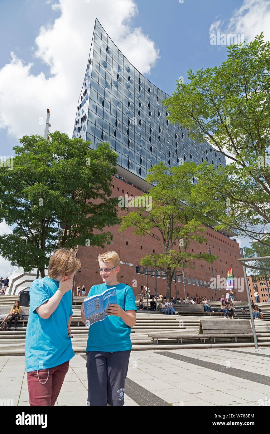 teenagers during language study travel studying their city guide in front of Elbe Philharmonic Hall, Hamburg, Germany Stock Photo