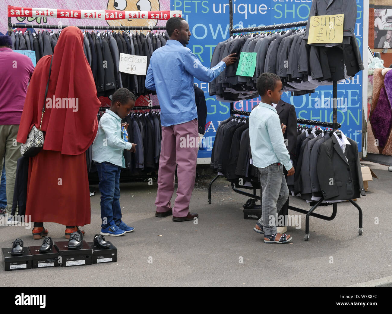 Family out shopping for boys suits on an outdoor market in England UK.  photo DON TONGE Stock Photo