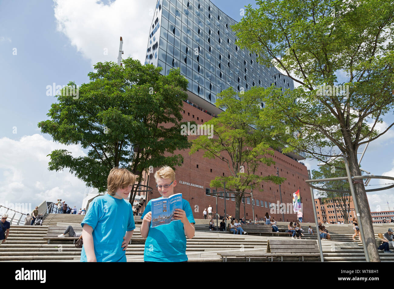 teenagers during language study travel studying their city guide in front of Elbe Philharmonic Hall, Hamburg, Germany Stock Photo