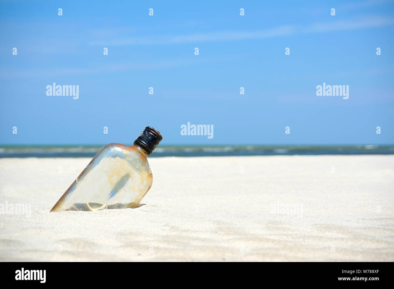 Bottle on a sand beach Stock Photo - Alamy