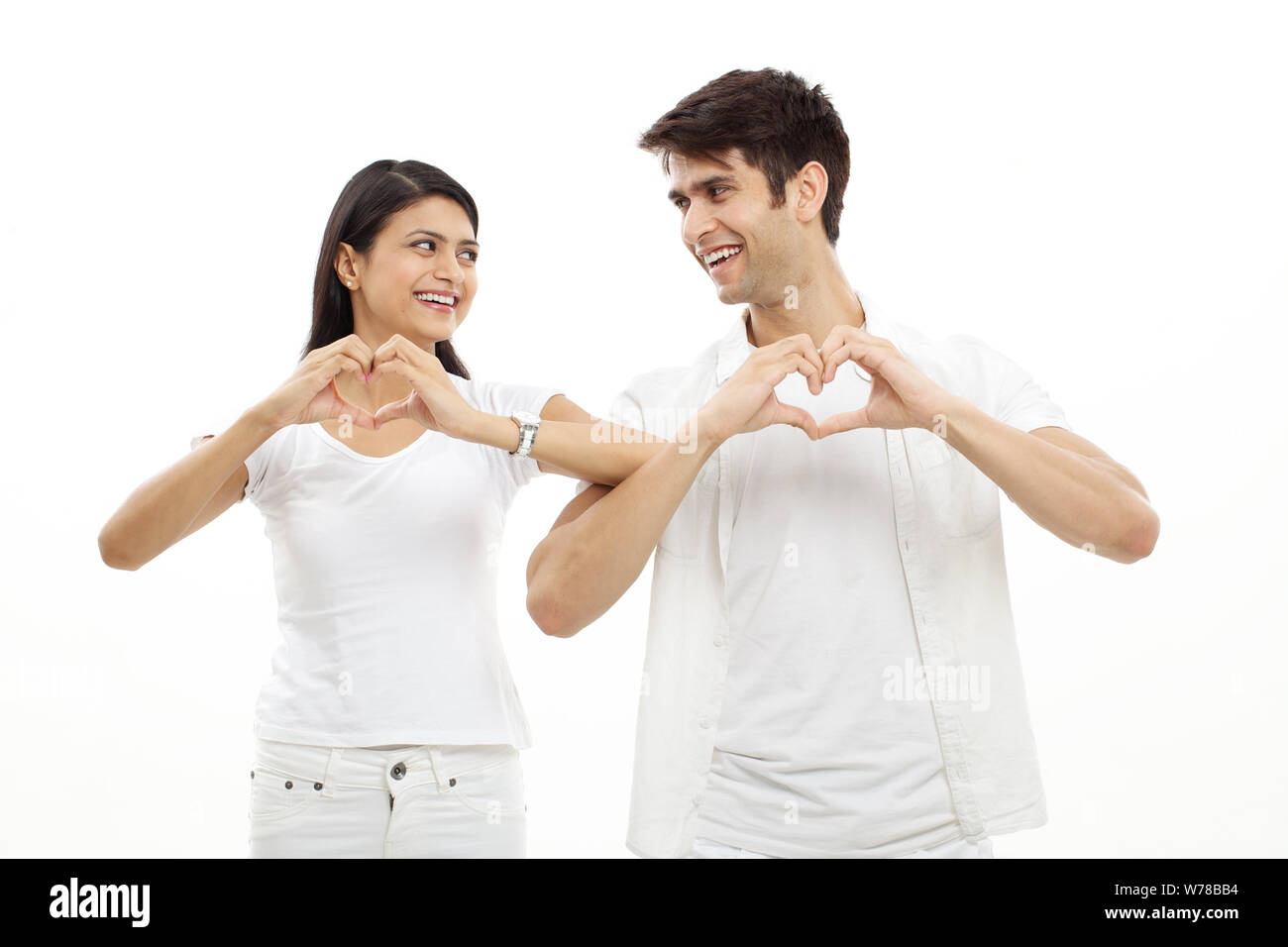 Young couple making heart shape with hands and smiling Stock Photo