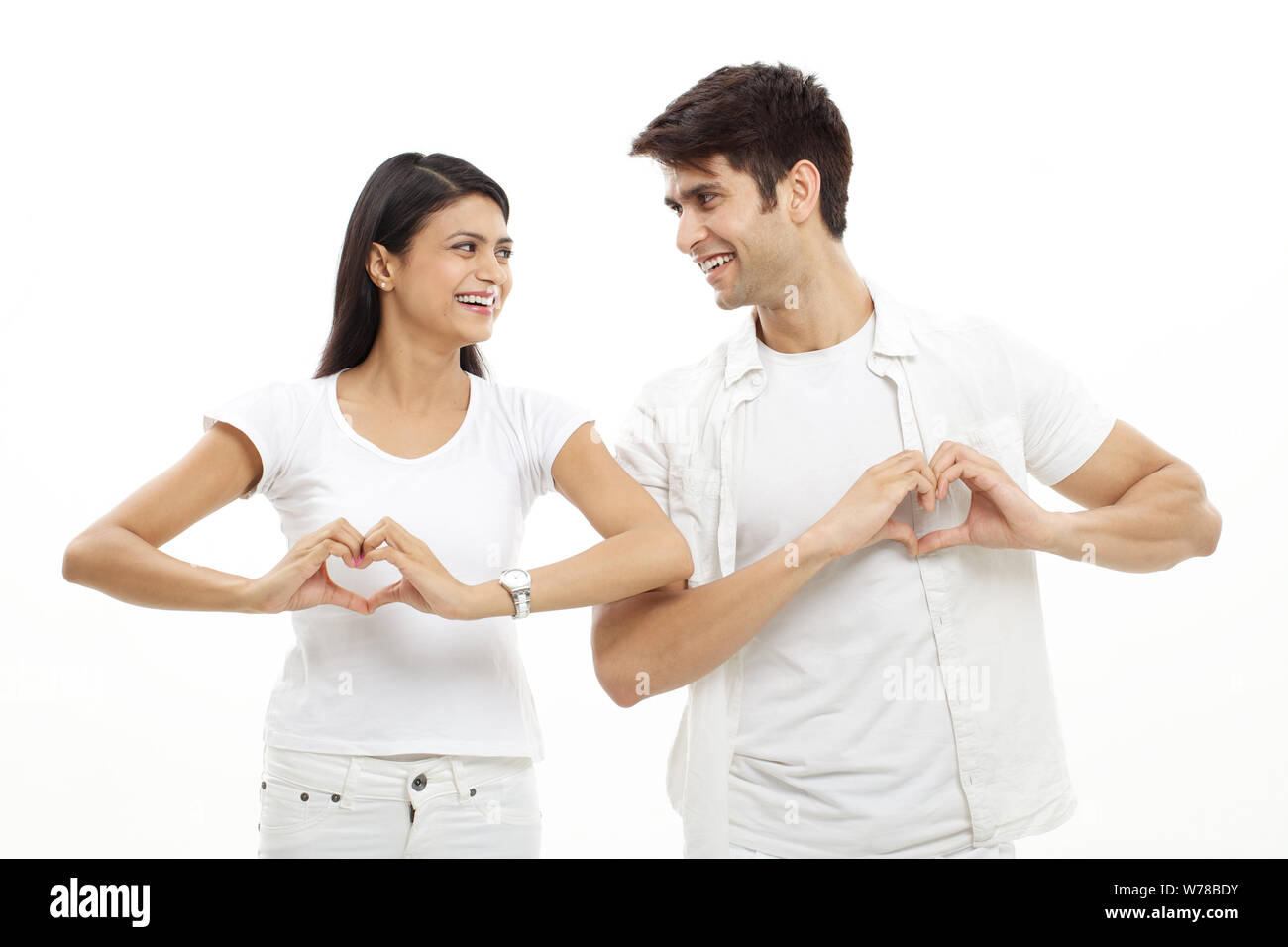 Young couple making heart shape with hands and smiling Stock Photo - Alamy