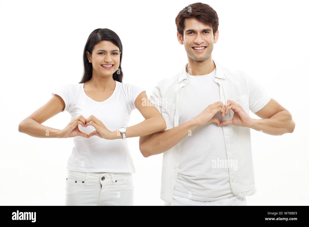 Young couple making heart shape with hands and smiling Stock Photo - Alamy