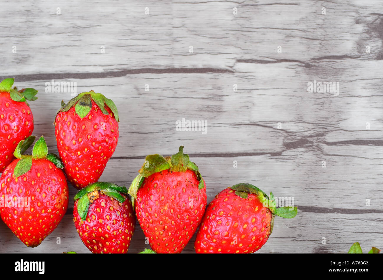 Strawberries over wooden background Stock Photo - Alamy