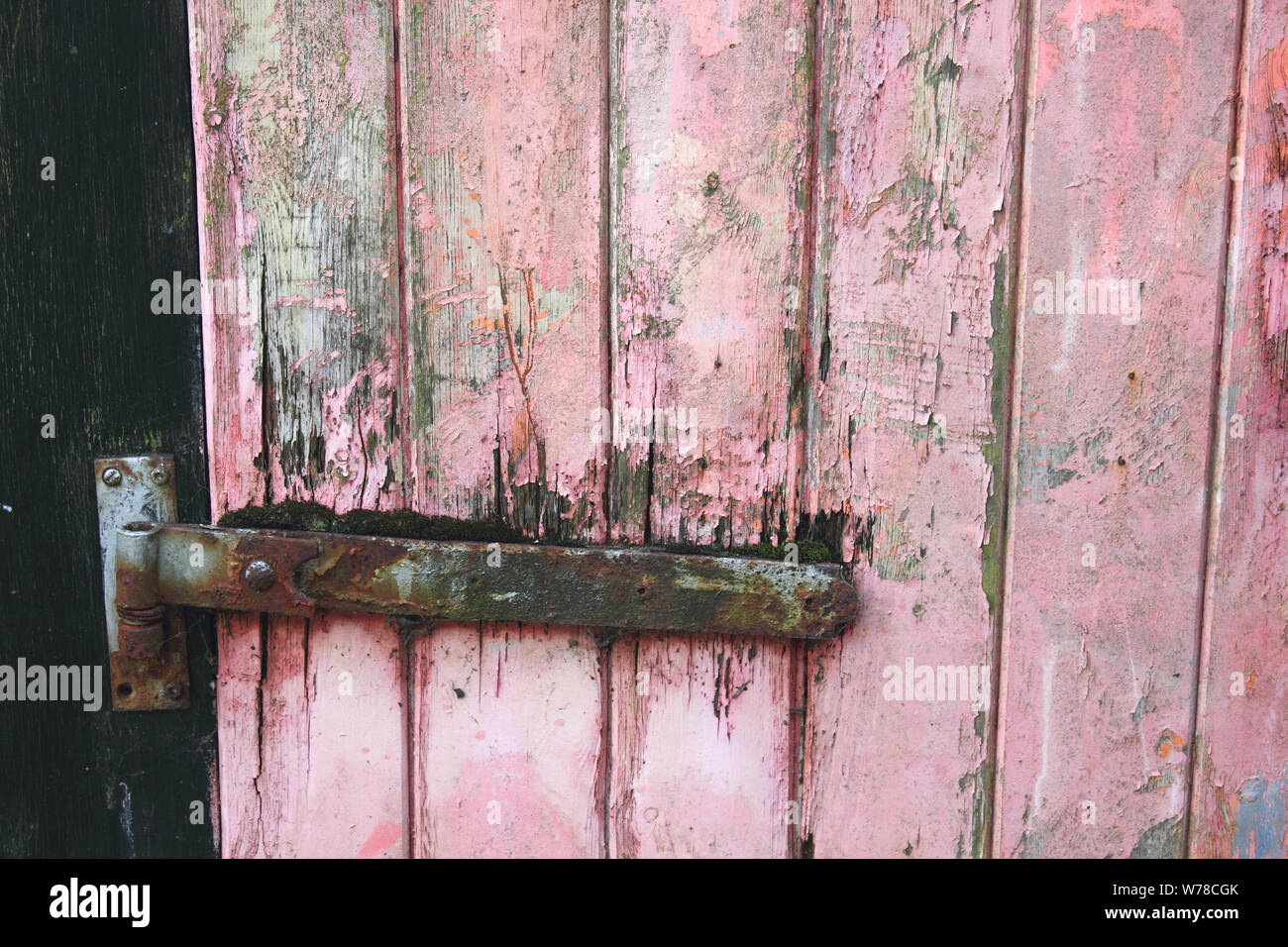 Old Wooden Garage Door With Distressed Weather Beaten Red Or Pink