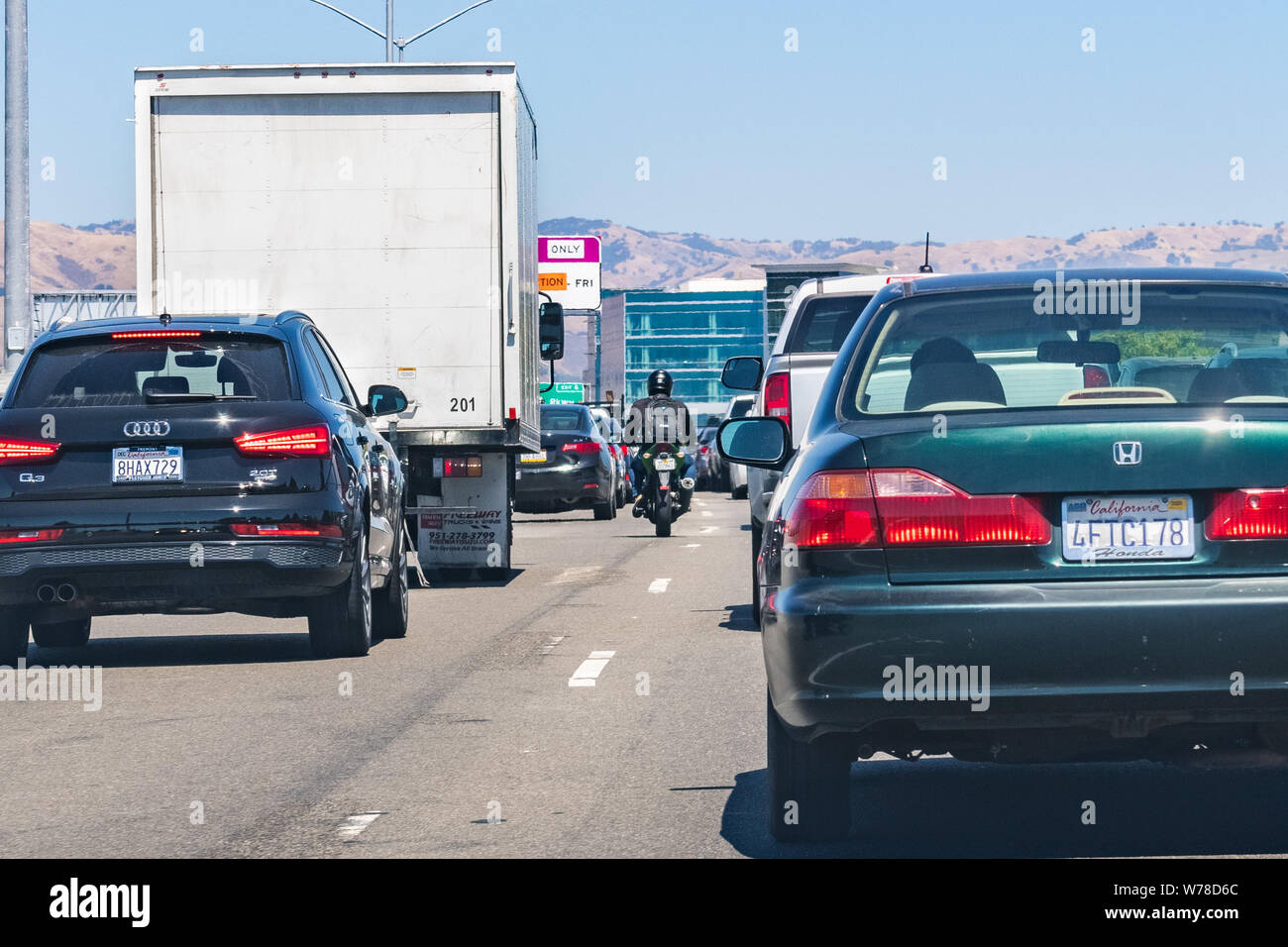 August 1, 2019 San Jose / CA / USA - Heavy traffic on one of the freeways crossing Silicon Valley; motorcyclist splitting lanes visible among cars Stock Photo