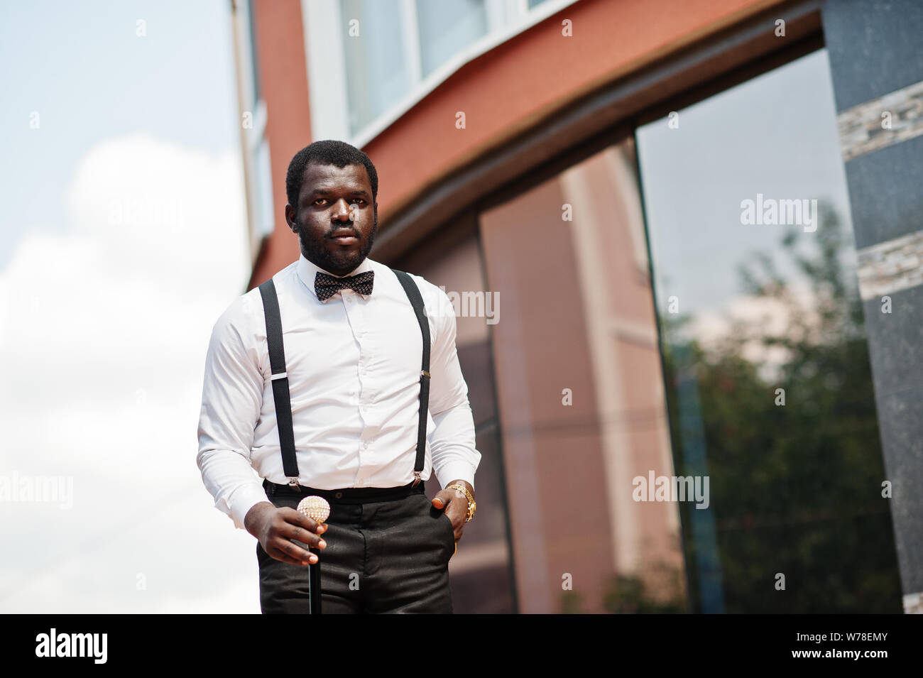 Free Photo  Handsome fashionable african american man in formal wear bow  tie and suspenders walking stick