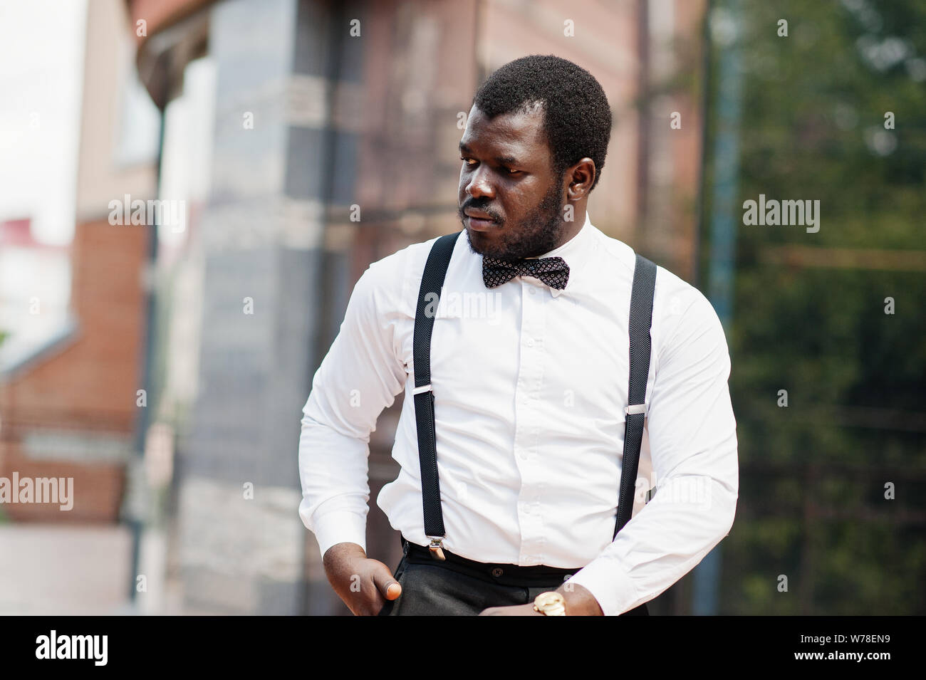 Handsome fashionable african american man in formal wear, bow tie and  suspenders, walking stick Stock Photo - Alamy