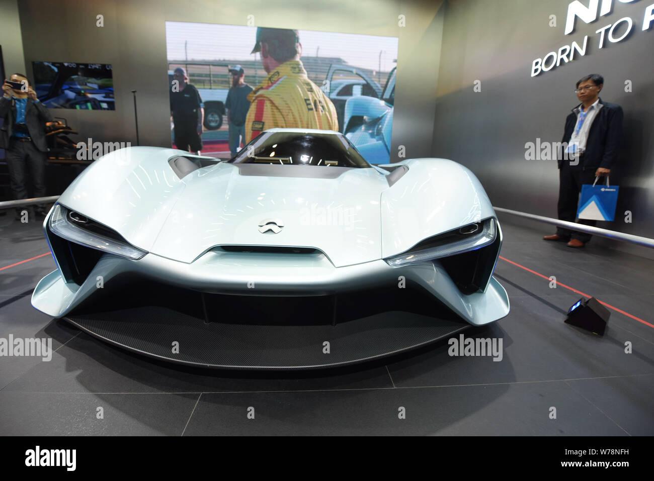 A Chinese visitor looks at a NextEV Nio EP9 electric supercar on display in Hangzhou city, east China's Zhejiang province, 10 November 2017.    Chines Stock Photo