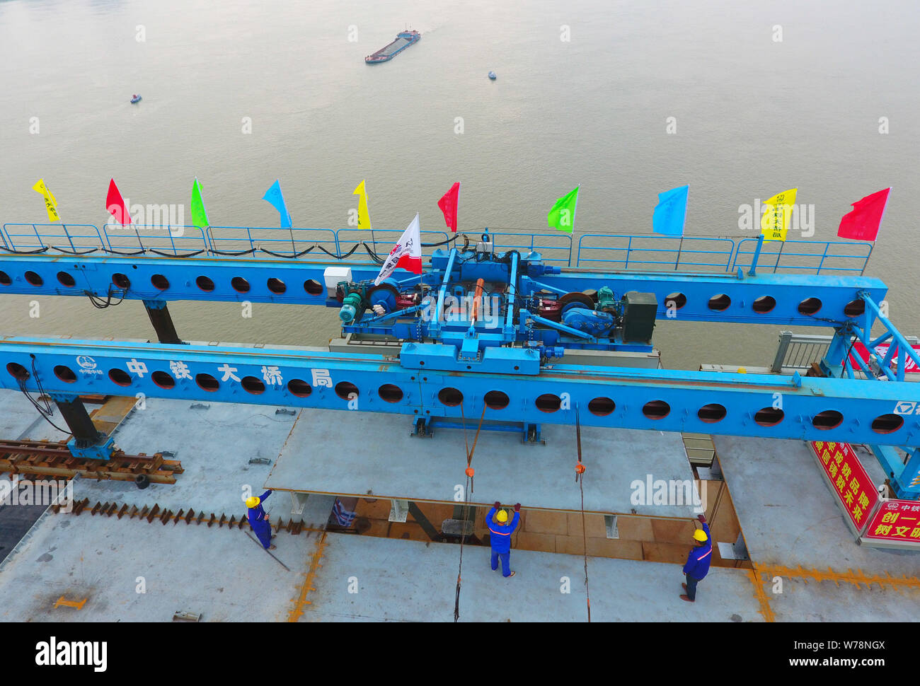 Chinese workers install the last steel bridge deck at the site of a reinforcement project of Jiujiang Yangtze River Bridge in Jiujiang city, east Chin Stock Photo