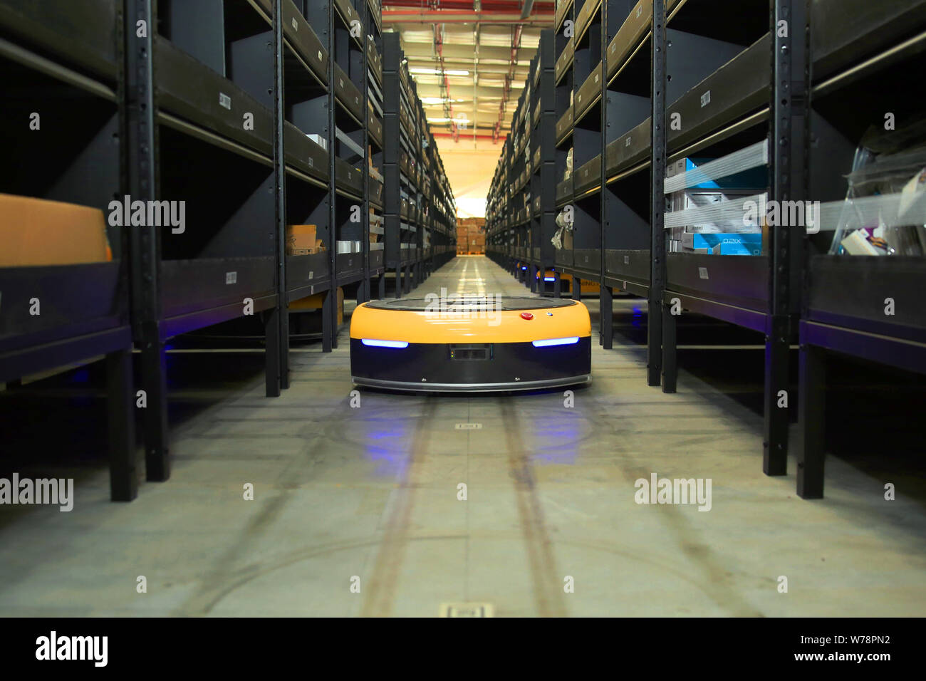 An AGV (Automated Guided Vehicle) robot which is responsible for delivering and sorting out parcels works in the electronics logistics base of Chinese Stock Photo