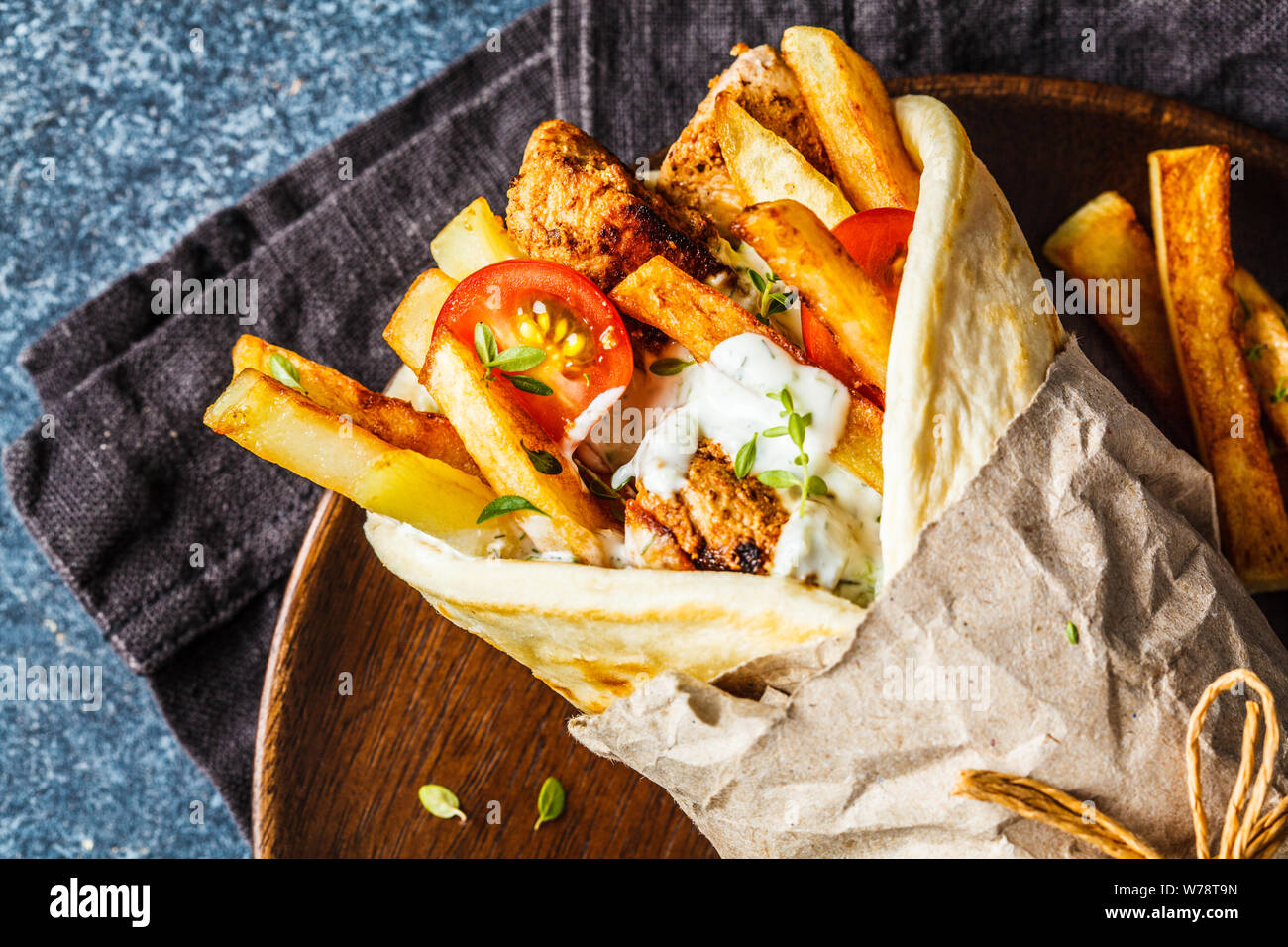 Gyros souvlaki wraps in pita bread with chicken, potatoes and tzatziki  sauce, blue background, top view Stock Photo - Alamy