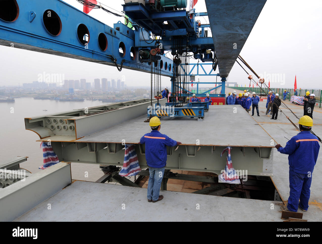 Chinese workers install the last steel bridge deck at the site of a reinforcement project of Jiujiang Yangtze River Bridge in Jiujiang city, east Chin Stock Photo