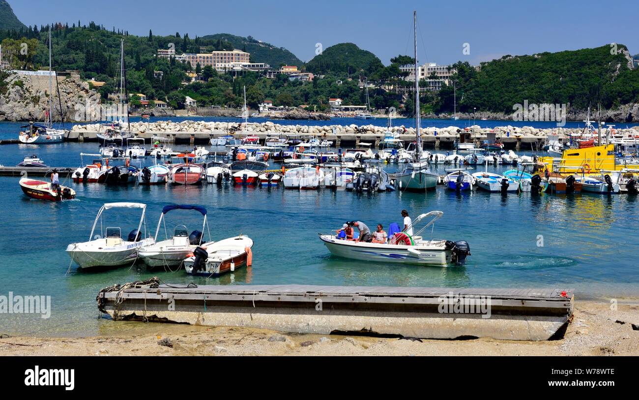 Tourist leaving aboard a holiday hire boat,Paleokastritsa Harbour beach,Corfu ,Greece Stock Photo