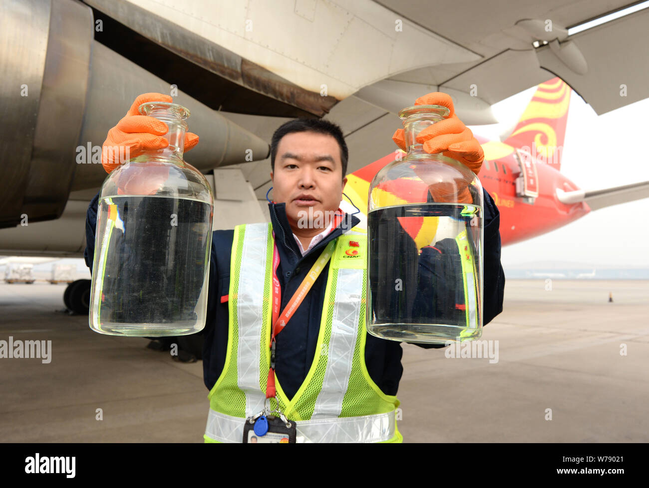 A Chinese ground crew member shows cooking oilblended aviation fuel to