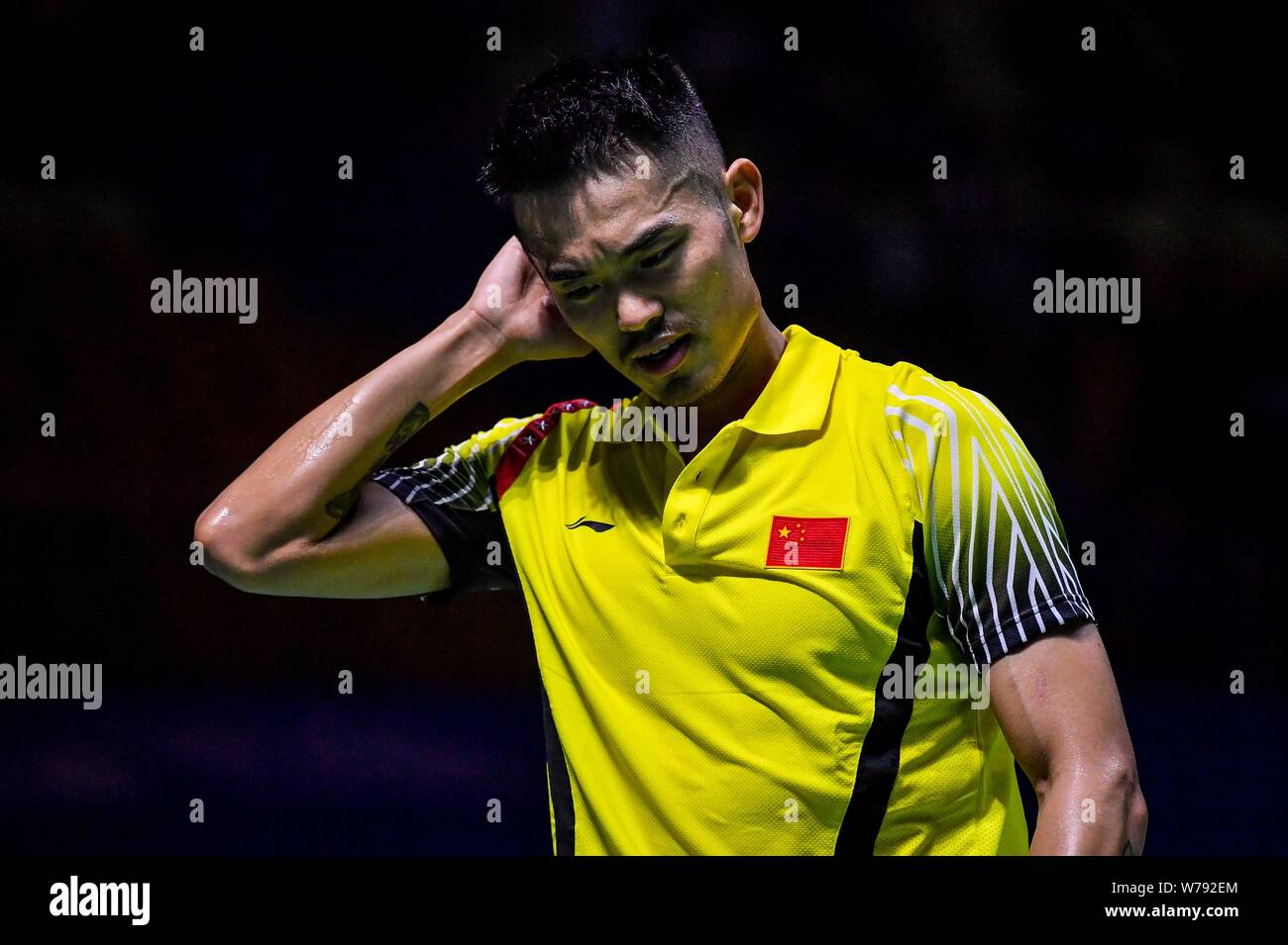Lin Dan of China reacts after losing a score to Christie Jonatan of Indonesia in their first round match of the mens singles during the Badminton Tah Stock Photo
