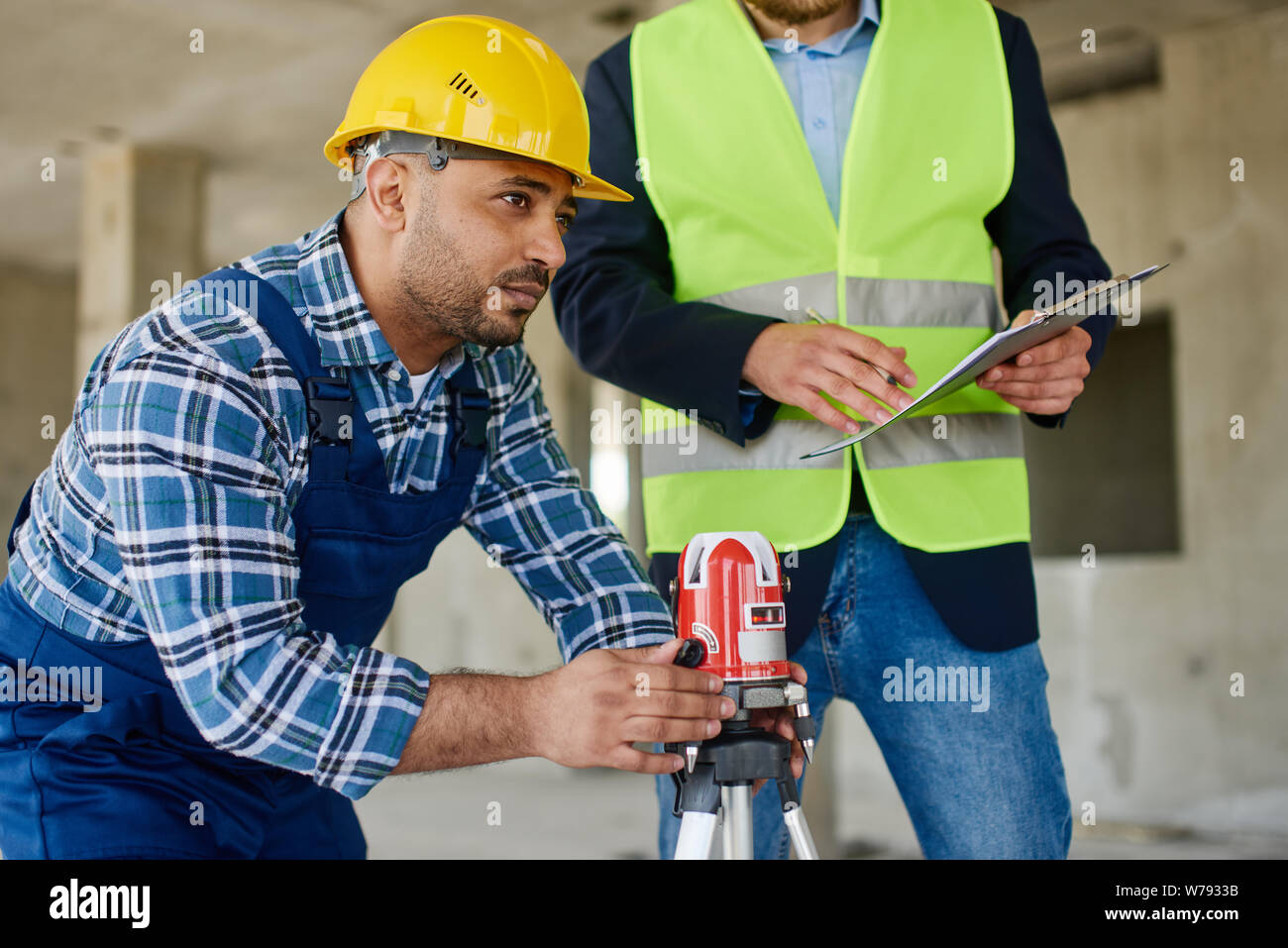 Two engineers on the construction use working equipment. Stock Photo
