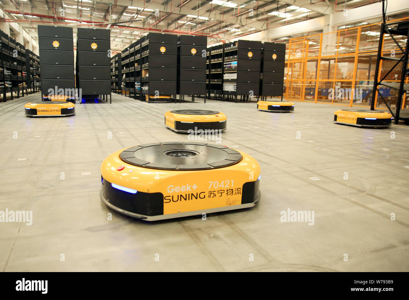 AGV (Automated Guided Vehicle) robots which are responsible for delivering and sorting out parcels work in the electronics logistics base of Chinese o Stock Photo