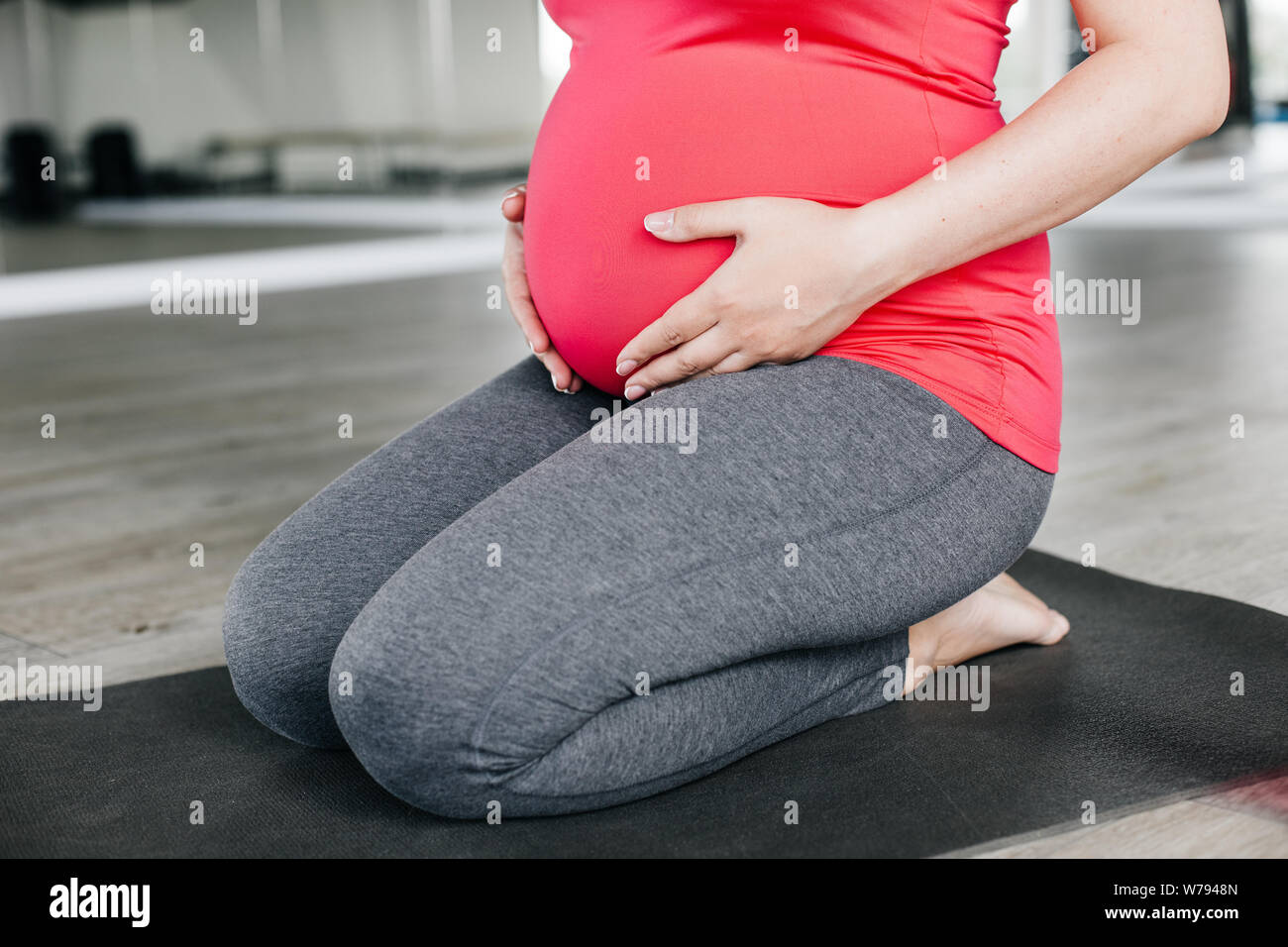 Close up shot of a pregnant woman touching her belly. Stock Photo