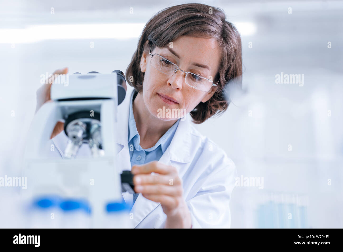 Woman does scientific research with the microscope in the lab. Stock Photo