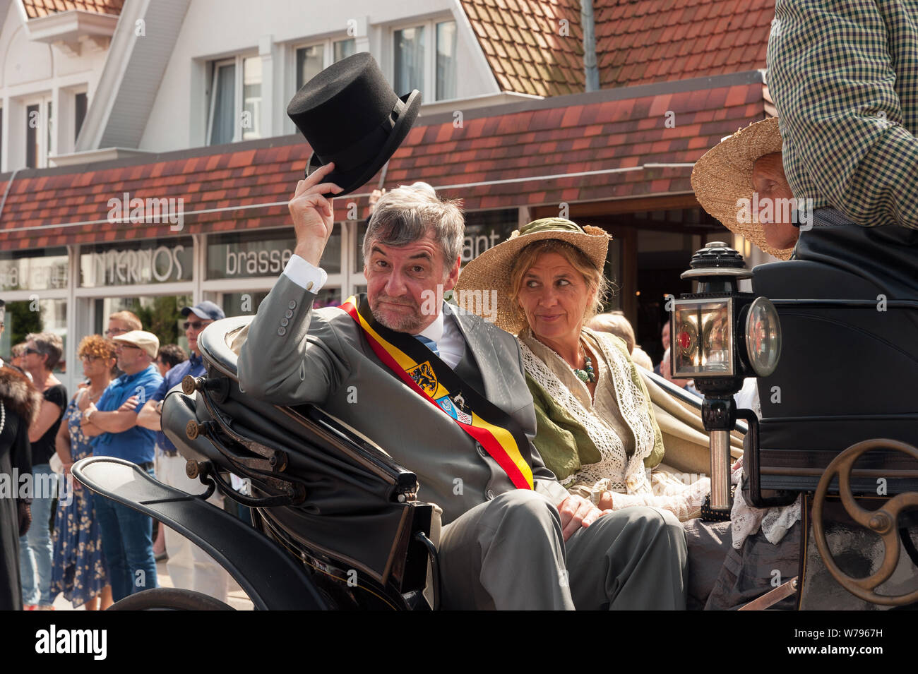 Wilfried Vandaele, mayor of De Haan, raises his hat in salute during the Trammelant parade. Stock Photo