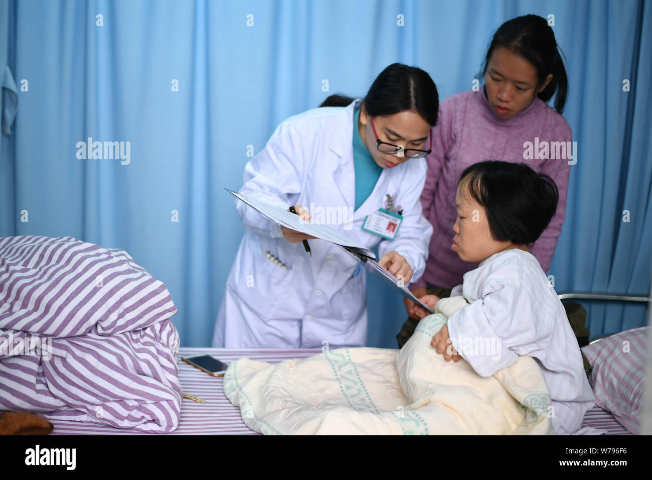 Chinese woman Wei Chunlan, right, who is just a little over three feet tall with dwarfism is examined by a doctor before giving birth by Caesarean sec Stock Photo