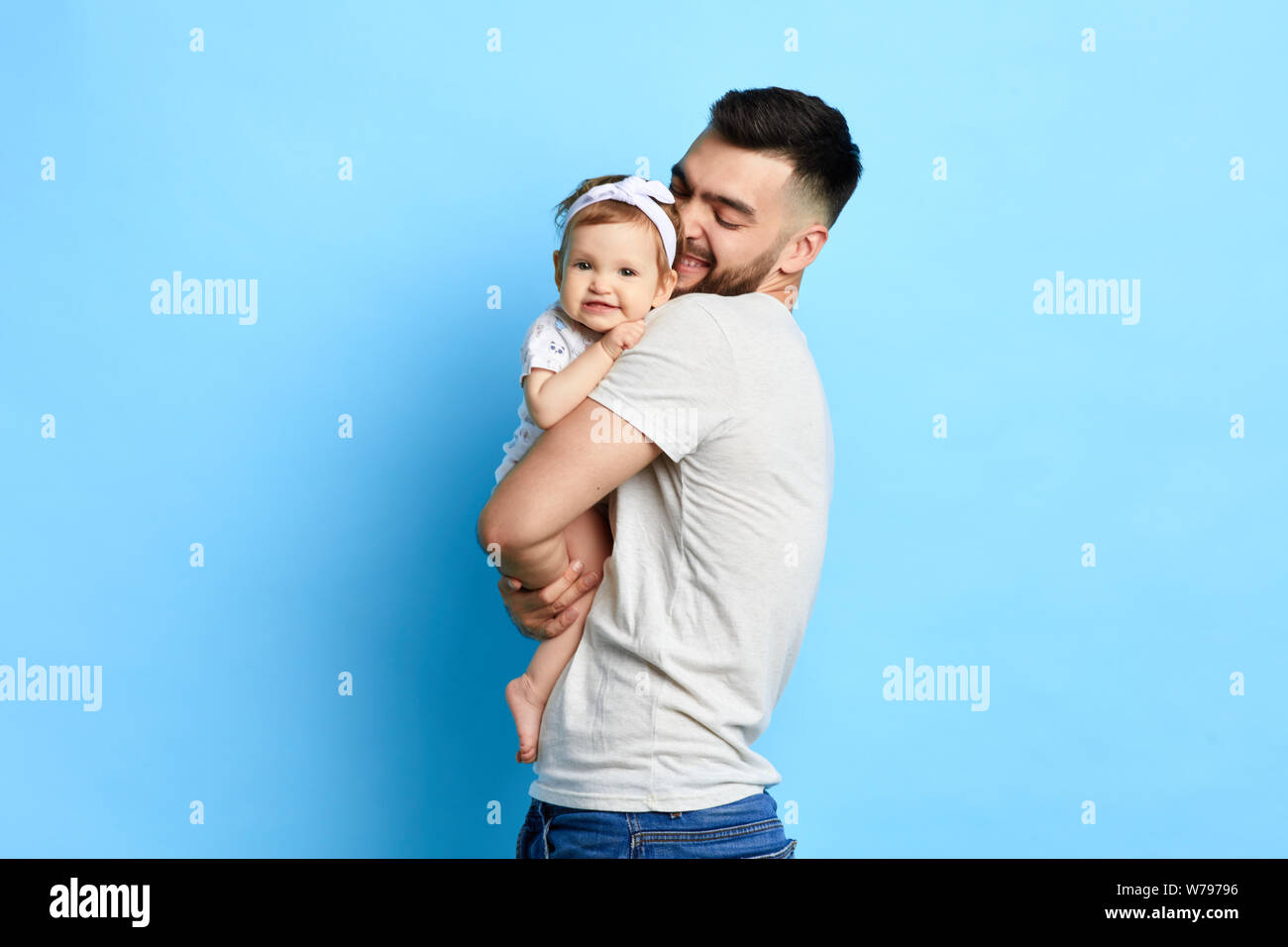 caring best daddy hugging his daughter, expressing love. isolated blue background. studioshot. Stock Photo
