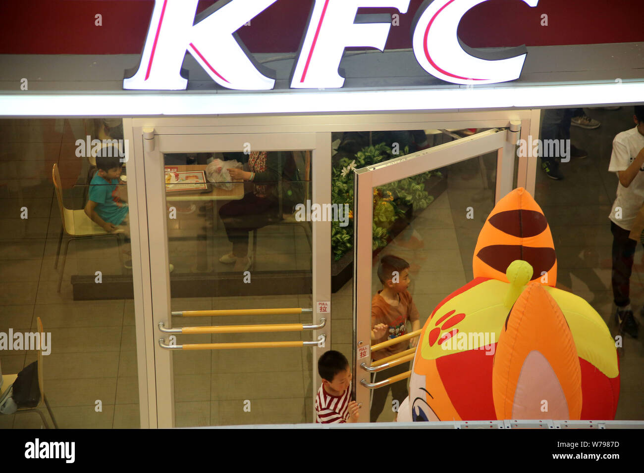 --FILE--Children exit a fastfood restaurant of KFC of Yum! Brands in Huaian city, east China's Jiangsu province, 14 May 2017.    It all began in Beiji Stock Photo