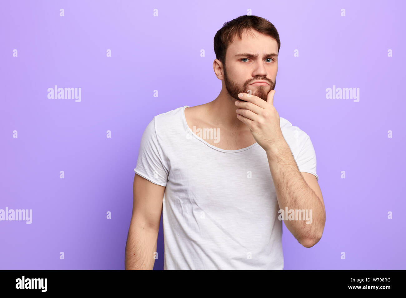 young puzzled man thinking about problem, trying to solve it, making a ...
