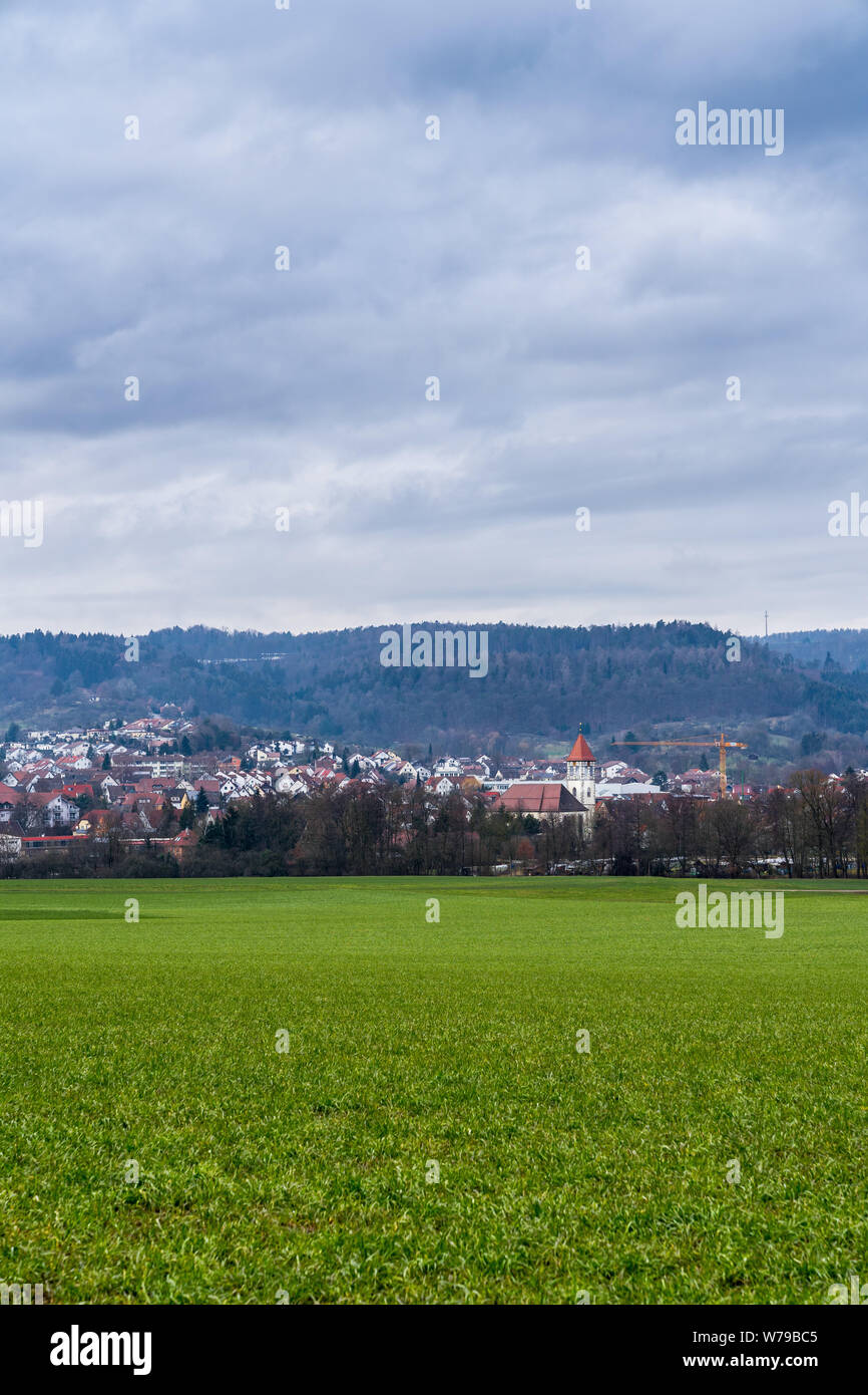 Germany, Rudersberg houses and church of town behind green meadow Stock Photo