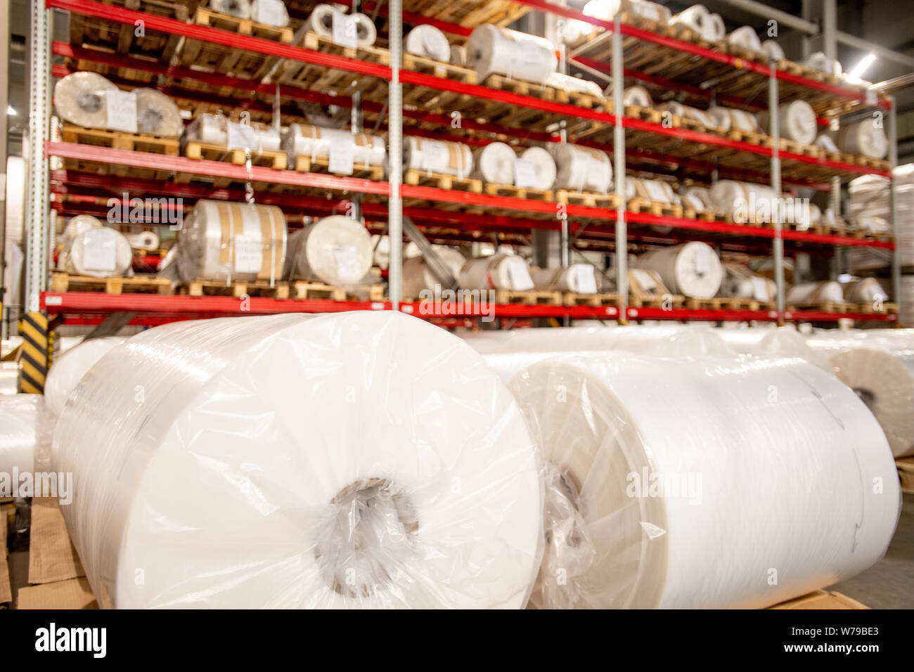 Racks of rolled and packed polyethylene film in storage area Stock Photo