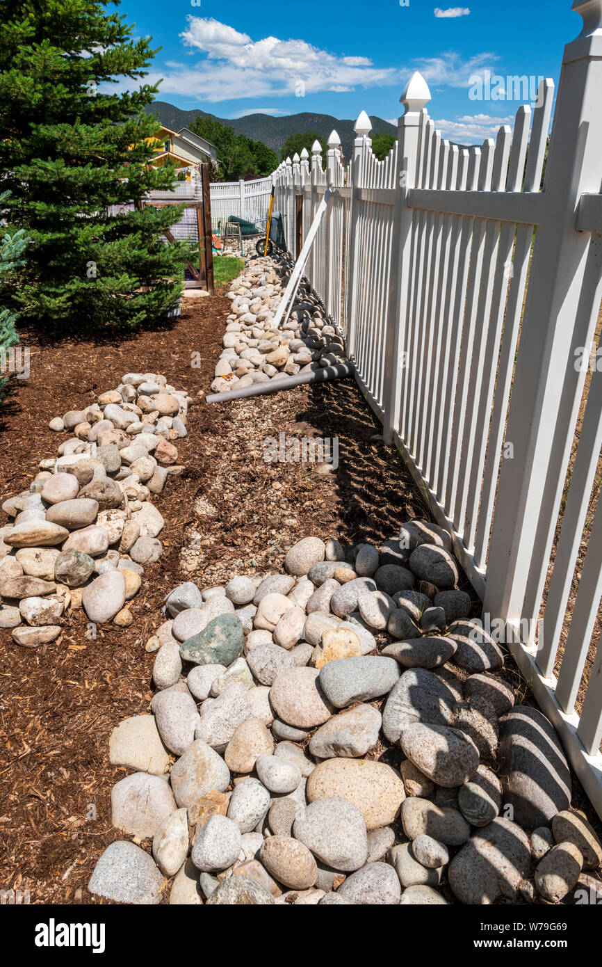 River rocks over weed landscape barrier used to create a garden border Stock Photo