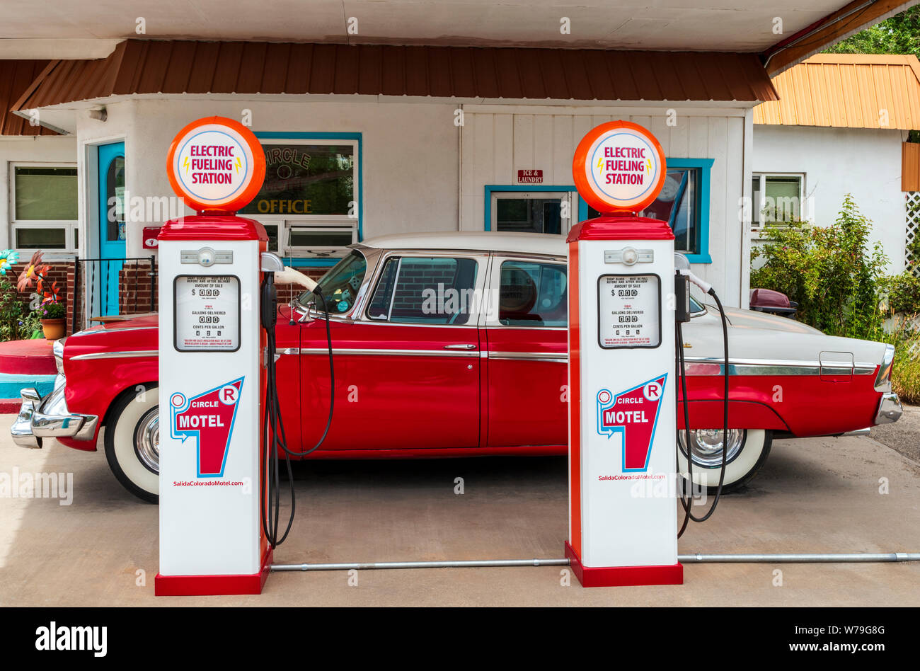 1955 Studebaker President classic car parked in front of antique gas pumps coverted to electric car chargers; The Circle R Motel; Salida; Colorado; US Stock Photo
