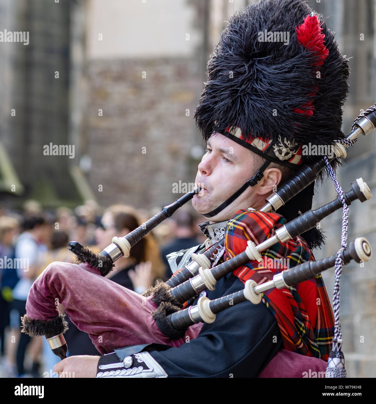 A piper entertains passersby near Edinburgh Castle on the Royal Mile, Edinburgh, Scotland, UK. Stock Photo