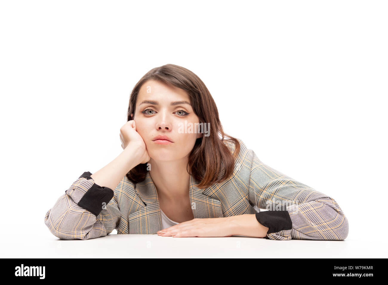 Young pensive or tired female student sitting by desk at lesson Stock Photo