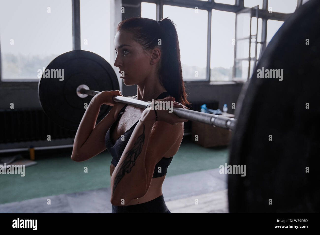 Focused on success. Attractive strong muscular female bodybuilder doing