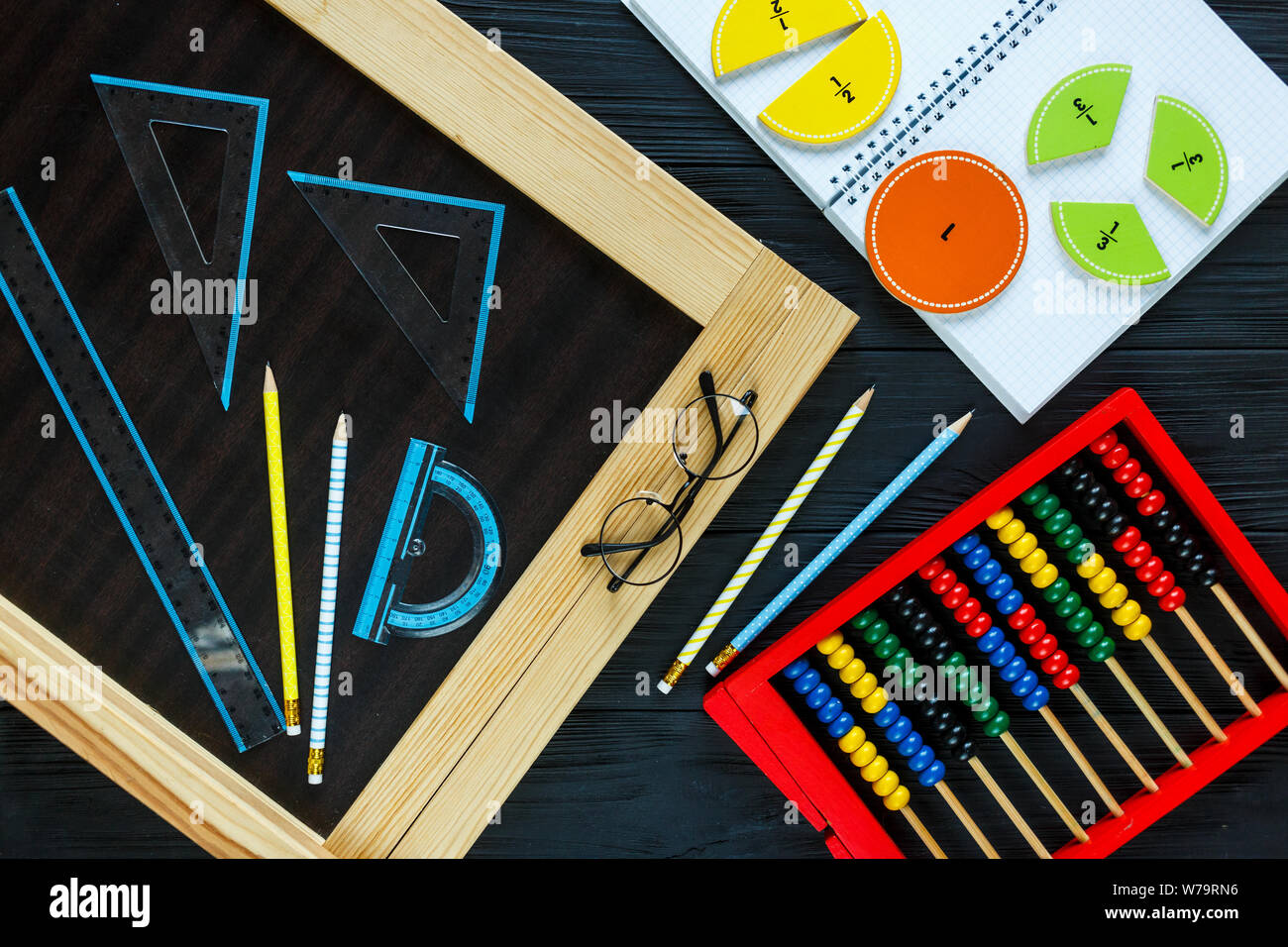 Creative Сolorful math fractions on dark background. Interesting funny math for kids. Education, back to school concept. Geometry and mathematics Stock Photo