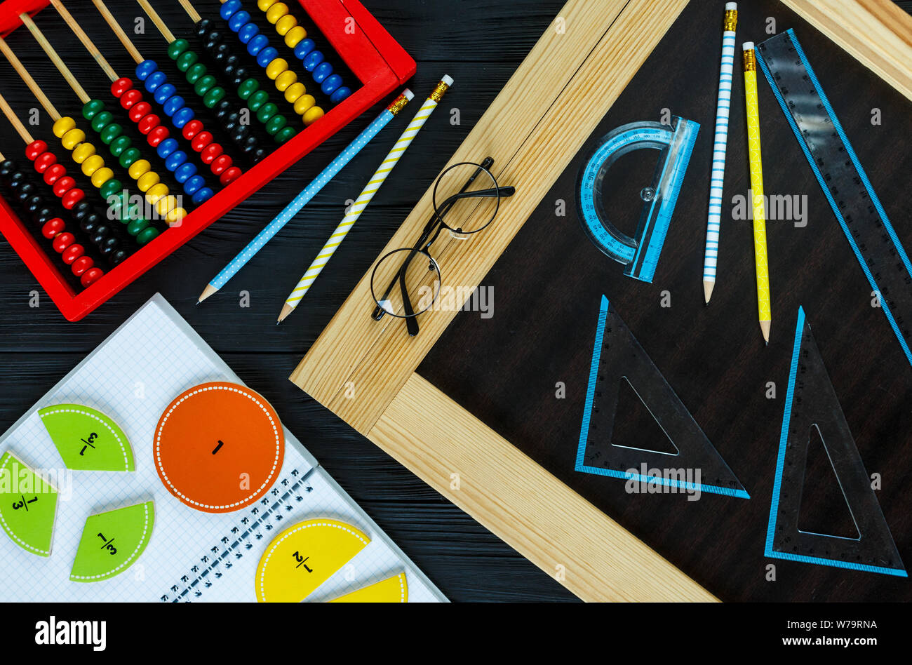 Creative Сolorful math fractions on dark background. Interesting funny math for kids. Education, back to school concept. Geometry and mathematics Stock Photo